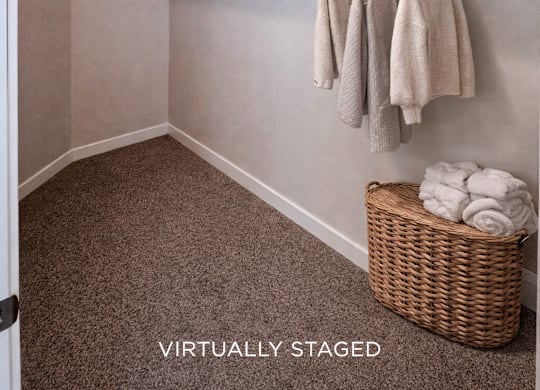A small, empty room with a basket of towels and towels hanging on a rack.
