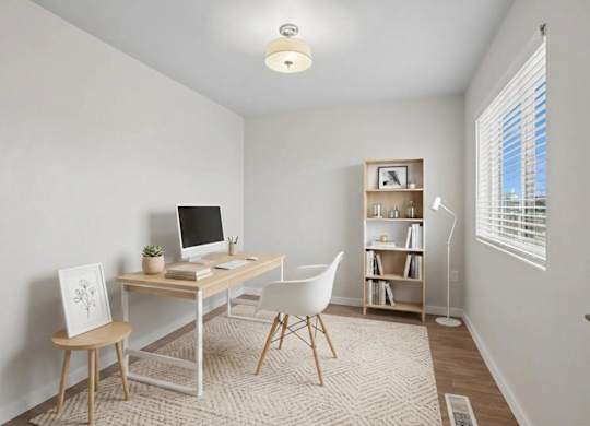 A room with a desk, chair, and bookshelf.