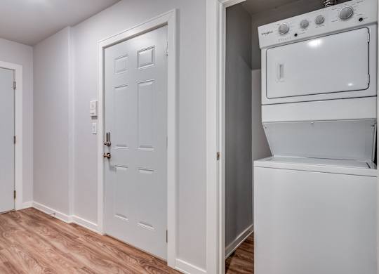 a laundry room with a washer and dryer and a white door