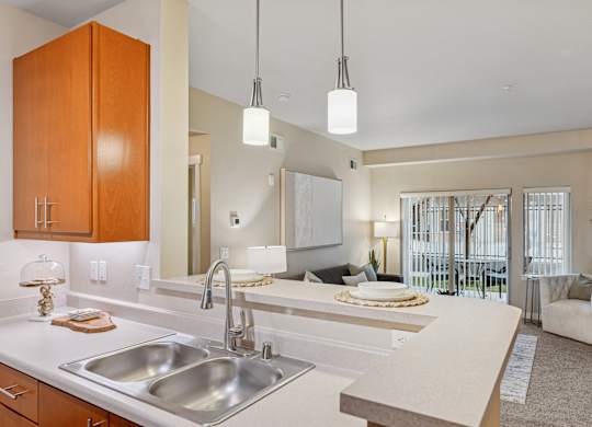 A modern kitchen with a large island and a dining area in the background.