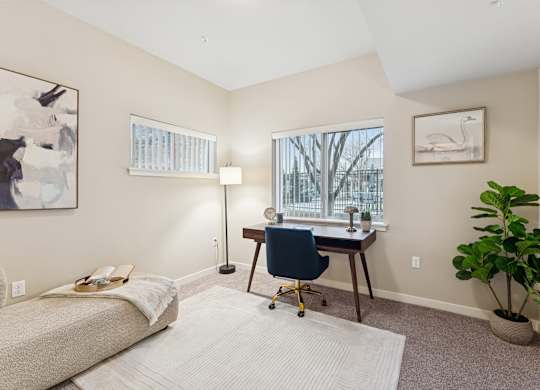 A room with a bed, desk, and chair.