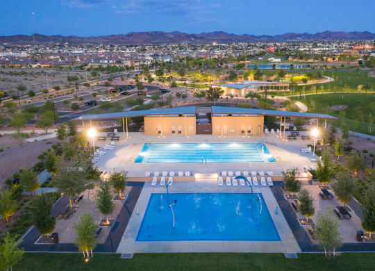 an aerial view of the pool at night with the city in the background