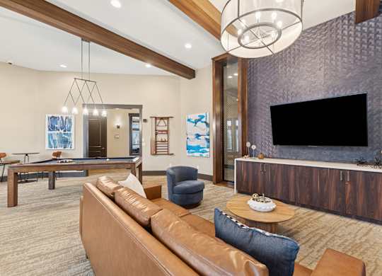 A modern living room with a pool table and a television.