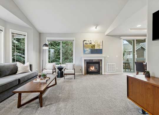 A modern living room with a fireplace and a painting on the wall.