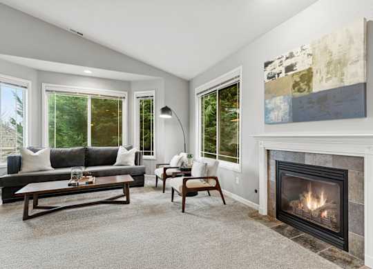 A living room with a fireplace and a painting on the wall.
