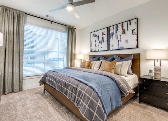 A bedroom with a bed, nightstands, and a ceiling fan.