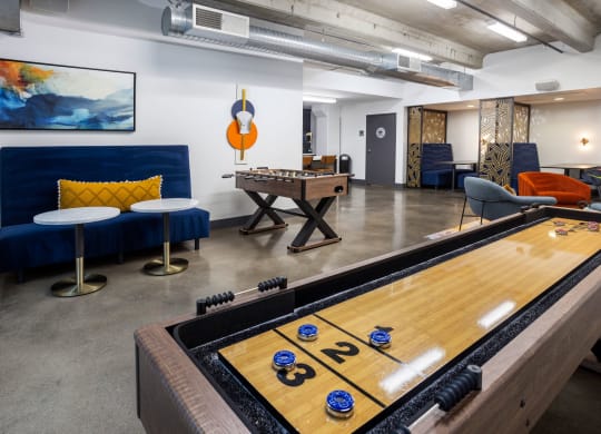 a game room with a shuffleboard table and a foosball