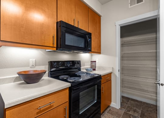 a kitchen with a stove and a microwave and a door to a closet
