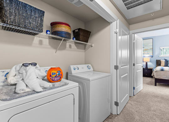 a washer and dryer in a laundry room with a door to the bedroom