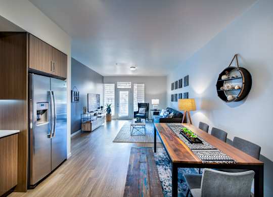 A modern kitchen with a wooden table and chairs.