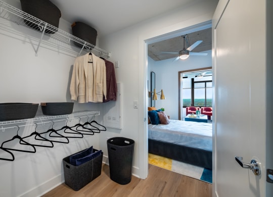 a bedroom with a bed and a closet with shelves and hooks