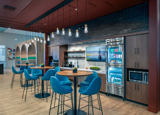 the lobby of a restaurant with blue chairs and a bar