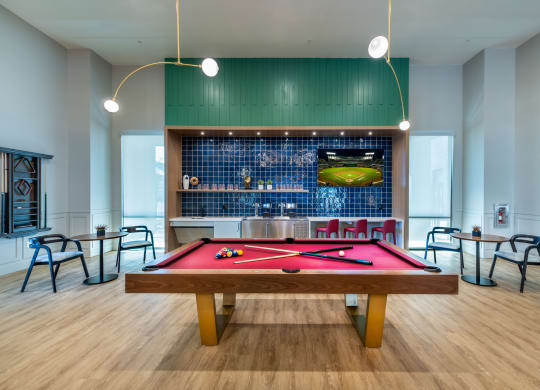 a pool table in a room with a bar and tables