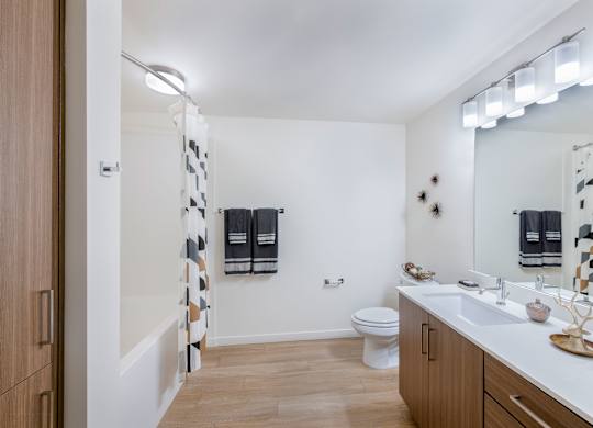 A bathroom with a toilet, sink, and a mirror.