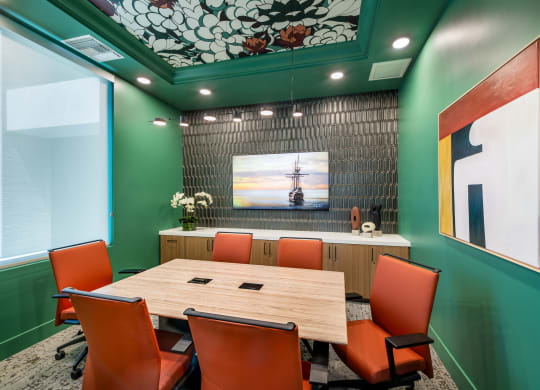 a conference room with a wooden table and orange chairs