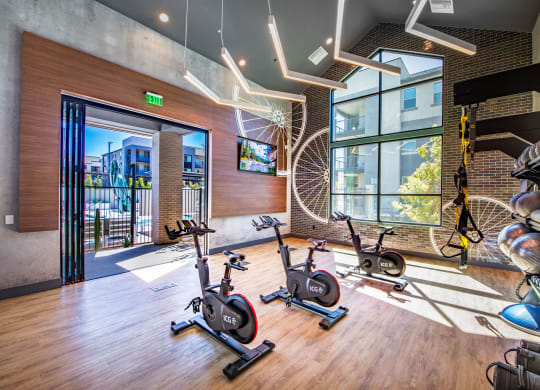 a gym with exercise bikes and a view of a building