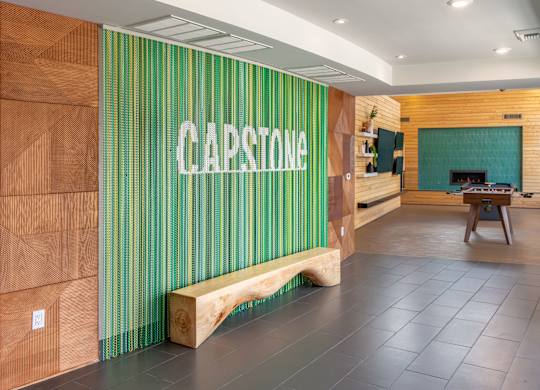 A room with a wooden bench and a green striped wall with the word