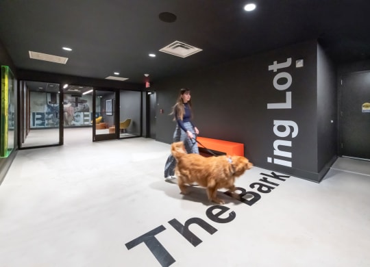 a woman walking her dog in a hallway of a building