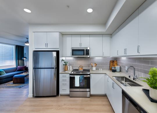 a kitchen with white cabinets and a stainless steel refrigerator