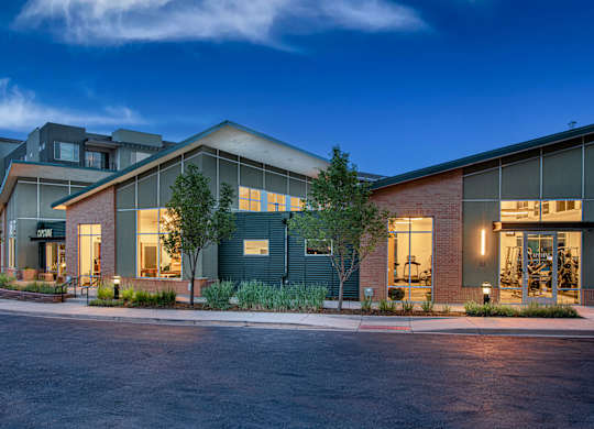 A modern building with a parking lot in front.