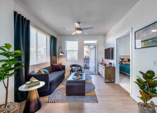 a living room with a couch and a coffee table and a ceiling fan
