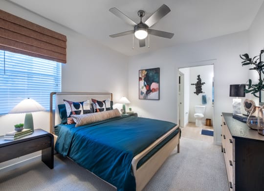a bedroom with a bed and a ceiling fan