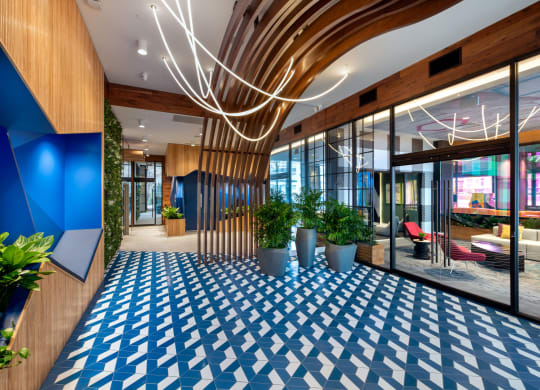 a lobby with a blue and white tile floor and glass doors