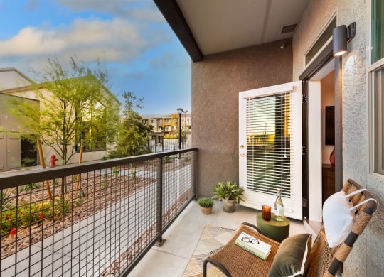 a balcony with a couch and a chair and a fence