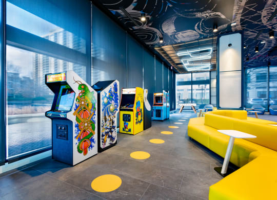 a room filled with video games and yellow couches