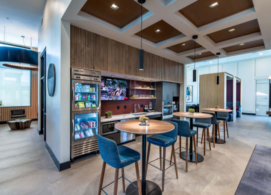 a lobby with tables and chairs and a bar with a television
