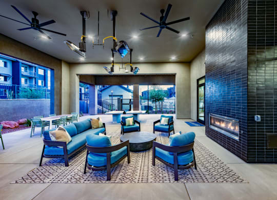 a lobby with blue chairs and couches and a fireplace