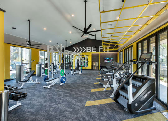 a gym with treadmills and other exercise equipment in the lobby of a building