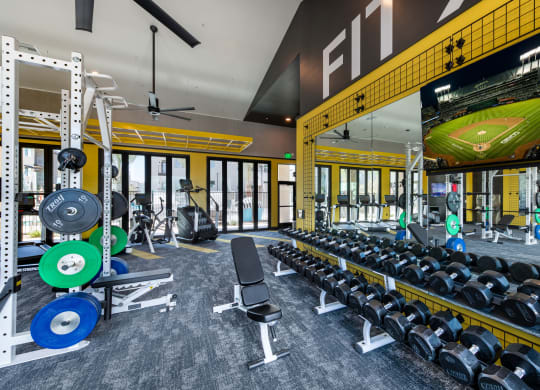 a gym with weights and a football scoreboard on the wall