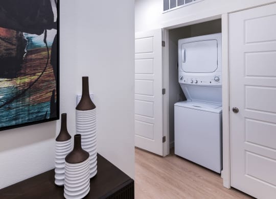 a white washer and dryer in a room with a door to a bathroom