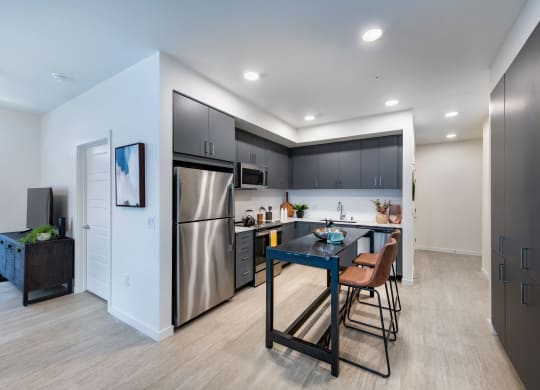 a kitchen with stainless steel appliances and a table with chairs