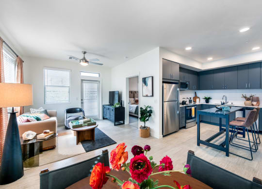a living room with a dining room and a kitchen with a table and chairs