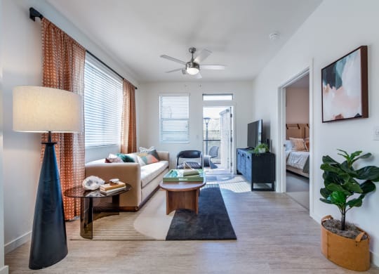 a living room with a couch and a table and a ceiling fan