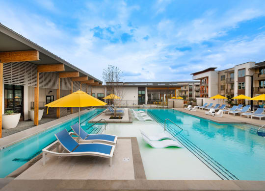 Corsair Apartments Pool with Lounge Chairs