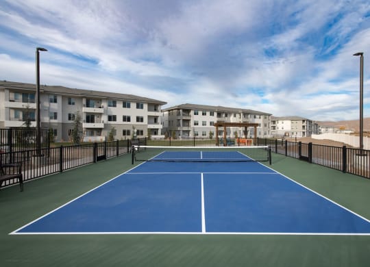 a pickleball court with apartments in the background