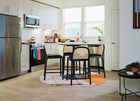 A kitchen with a table and chairs in the middle of the room.