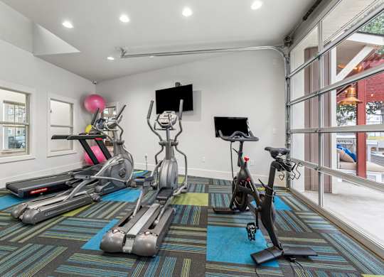 A room with exercise equipment and a TV.