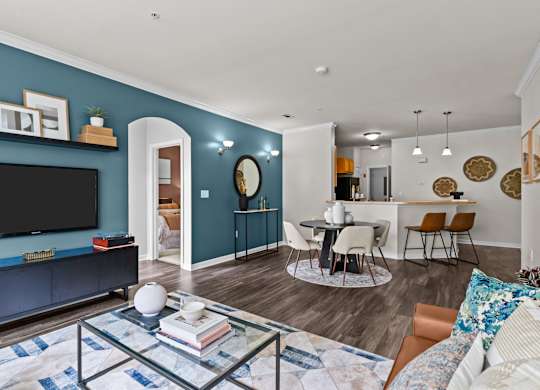 A living room with a blue wall and a black television.