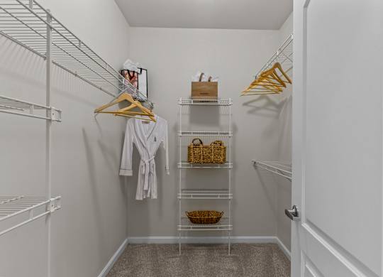 A white closet with a white robe hanging on a hanger.