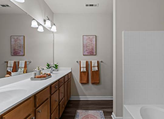 A bathroom with a white tub and a white sink.