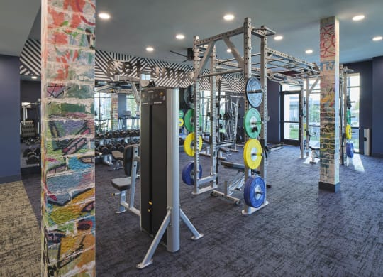 a gym with weights and cardio equipment in a building