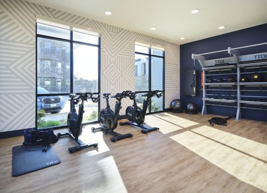 a home gym with exercise equipment and windows