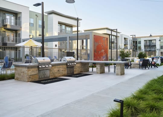a communal area with tables and chairs and buildings in the background
