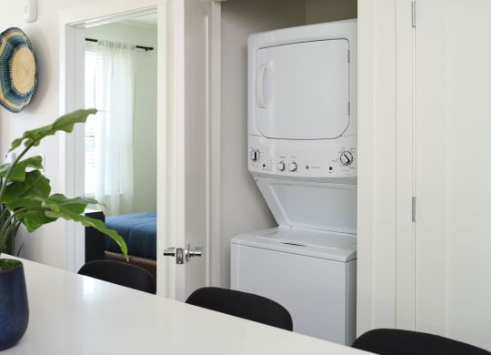 a white washer and dryer in a white laundry room
