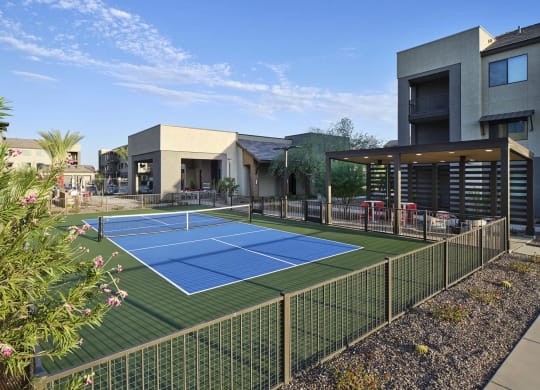 a tennis court is in the middle of a house with a fence