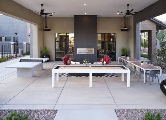 an outdoor patio with tables and chairs and a fireplace